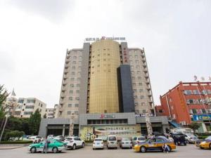 een groot gebouw met auto's geparkeerd op een parkeerplaats bij Jinjiang Inn Xuzhou Jinshanqiao Development Zone Dongshan Road in Xuzhou