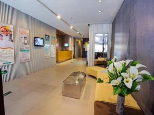 een lobby met een bank en een vaas met bloemen bij Jinjiang Inn Xuzhou Jinshanqiao Development Zone Dongshan Road in Xuzhou