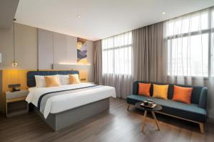 a bedroom with a bed and a couch at Home Inn Selected Xiamen University Zhongshan Road in Xiamen +107 photos