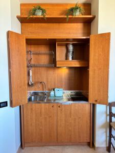 a kitchen with wooden cabinets and a sink at La Casetta in Cagliari