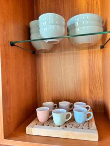 a shelf with cups and bowls on it at La Casetta in Cagliari