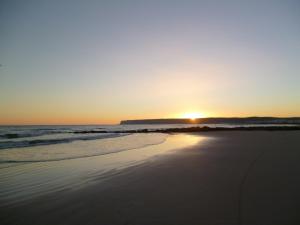 a sunset on a beach with the ocean at Casa Entre Armonías in Zahara de los Atunes