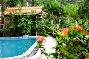 a swimming pool in front of a house with plants at Trang An Memory Homestay in Ninh Binh