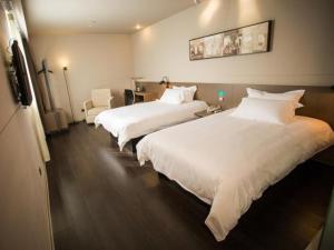 una habitación de hotel con 2 camas y una silla en Jinjiang Inn Select Fuding Railway Station en Fuding