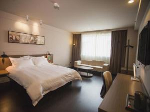 Habitación de hotel con cama grande y sofá en Jinjiang Inn Select Fuding Railway Station en Fuding