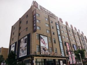um grande edifício com anúncios na lateral em Jinjiang Inn Select Fuding Railway Station em Fuding