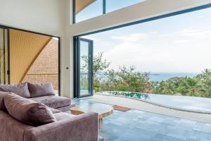 an open living room with a view of the ocean at Villa Azure in Koh Samui