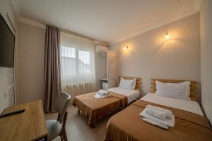 a hotel room with two beds and a table at Hotel & CoWorking in Tbilisi City