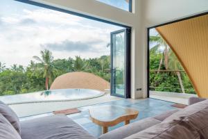a living room with a large window and a tub at Villa Azure in Koh Samui 