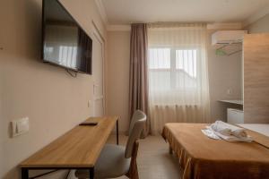a room with two beds and a table and a window at Hotel & CoWorking in Tbilisi City