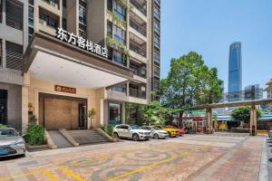a parking lot with cars parked in front of a building at Oriental Hotel in Dongguan