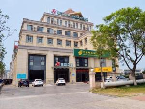 a large building with cars parked in front of it at Jinjiang Inn Weihai Shandong University in Weihai