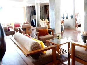 een woonkamer met banken en tafels bij Ladawan Boutique Hotel in Ban Pak Khlong