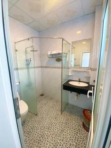 um banheiro com box de vidro e pia em Khu Nghỉ Dưỡng Đoàn 298 Khu 7 Tầng em Long Hai