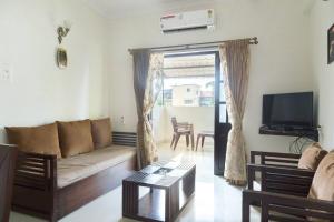 a living room with a couch and a tv at 1bhk Premium BS1 - Candolim Calangute Area in Candolim