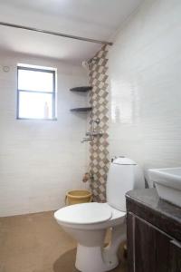 a bathroom with a white toilet and a sink at 1bhk Premium BS1 - Candolim Calangute Area in Candolim