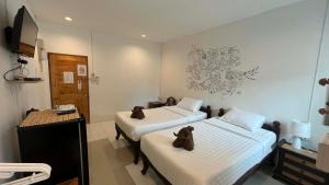 a room with two beds and a television in it at OldTown Boutique House Sukhothai in Sukhothai +80 photos