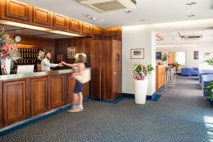 a young girl is standing at a counter in a salon at Hotel Curtis Centrale in Alassio