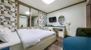Un dormitorio con una cama, un escritorio y un espejo. en Dubai Motel, en Daejeon