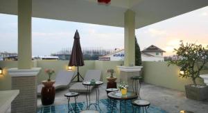 a patio with chairs and tables and an umbrella at The Xym Hotel in Chiang Mai