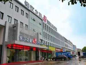 un edificio con un'auto parcheggiata di fronte di Jinjiang Inn Suzhou Baiyang Bay Jin Chang New Town a Suzhou