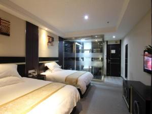 a hotel room with two beds and a flat screen tv at Goldmet Inn Wuxi Gonghu Avenue Wanxiangcheng in Wuxi