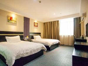 um quarto de hotel com duas camas e uma janela em Goldmet Inn Wuxi Gonghu Avenue Wanxiangcheng em Wuxi