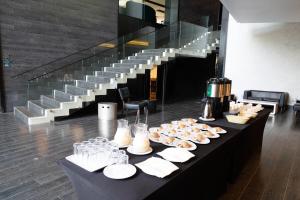 圣地亚哥Wyndham Santiago Pettra的楼梯旁的桌子上摆着几盘食物。