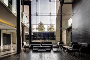 圣地亚哥Wyndham Santiago Pettra的大堂配有沙发、椅子和大窗户