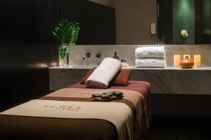 a bathroom with a bed with a sink and towels at Wyndham Santiago Pettra in Santiago +26 photos