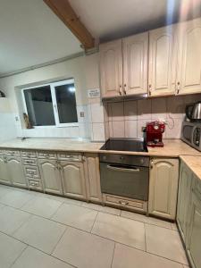 a kitchen with wooden cabinets and a red appliance in it at Guest House Robin Hud in Cherni Osŭm