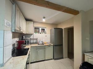 a kitchen with white cabinets and a stainless steel refrigerator at Guest House Robin Hud in Cherni Osŭm