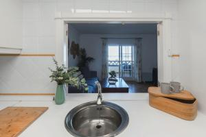 a kitchen with a sink and a living room at Vista Marina de Isla Canela in Isla del Moral +20 photos