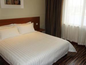 מיטה או מיטות בחדר ב-Jinjiang Inn Select Yantai Penglaige