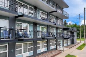 an apartment building with balconies and chairs on it at Clarion Pointe Rhinelander Downtown in Rhinelander