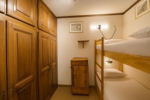 ein kleines Zimmer mit zwei Etagenbetten und einem Schrank in der Unterkunft Smartstay Caron - Val Thorens in Val Thorens