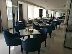 MagouにあるJinjiang Inn Select Taizhou Jiangyan Coach Terminalのテーブルと椅子とカウンターのあるレストラン