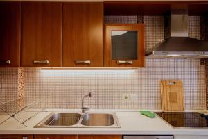 Il dispose d'une cuisine avec un évier et un mur carrelé. dans l'établissement Athens Riviera Luxury Voula Residence, à Athènes 79 autres photos