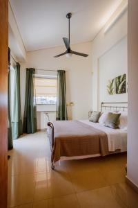 une chambre avec un lit et un ventilateur de plafond dans l'établissement Athens Riviera Luxury Voula Residence, à Athènes