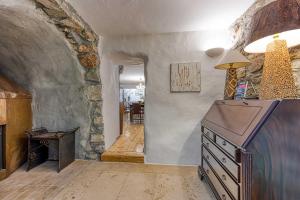 a room with a stone wall and a dresser and a table at Beautiful stone holiday house MENTA I in Bajčići
