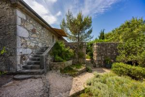 a stone house with stairs and a stone wall at Beautiful stone holiday house MENTA I in Bajčići