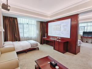 ein Hotelzimmer mit einem Bett und einem Flachbildfernseher in der Unterkunft Guilin China Southern Pearl Hotel in Guilin