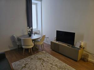 a living room with a table and a flat screen tv at Casa da Lara in Aveiro