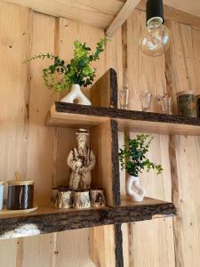 a wooden shelf with a statue and plants on it at Будиночок між річками Гирло in Iltsi +3 photos