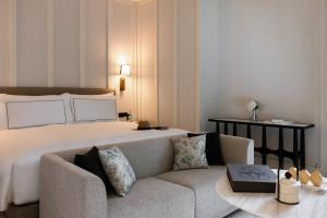 a hotel room with a large bed and a couch at METT Singapore in Singapore