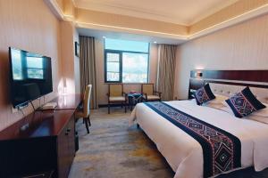 ein Hotelzimmer mit einem Bett und einem Flachbildfernseher in der Unterkunft Guilin China Southern Pearl Hotel in Guilin + 75 Fotos