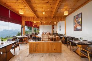 a restaurant with wooden ceilings and tables and chairs at WelcomHeritage Arka Resort & Spa, Rishikesh in Bijni
