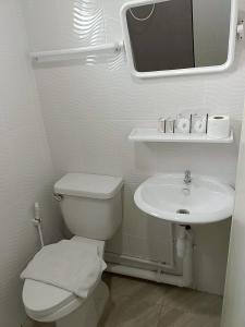 Un baño blanco con inodoro y lavabo. en Comfy Hotels Suvarnabhumi Airport, en Samut Prakan