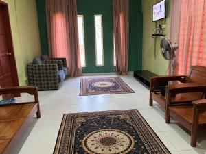 a living room with green walls and a rug on the floor at Homestay pantai dungun in Dungun
