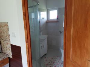 a bathroom with a toilet and a glass shower at Horváth Apartmanok in Mórahalom